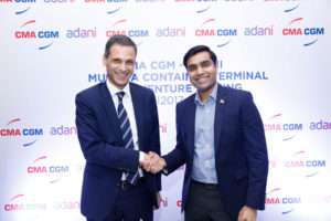 Rodolphe Saade and Karan Adani shake hands after signing the Munda CT4 deal