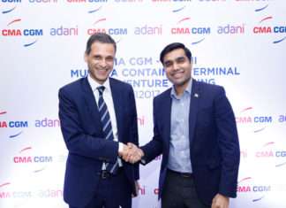 Rodolphe Saade and Karan Adani shake hands after signing the Munda CT4 deal