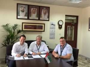Captain Cliff Brand (centre) signs the deal to buy two Liebherr mobile harbour cranes