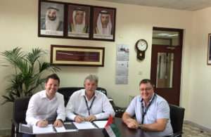 Captain Cliff Brand (centre) signs the deal to buy two Liebherr mobile harbour cranes