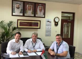 Captain Cliff Brand (centre) signs the deal to buy two Liebherr mobile harbour cranes