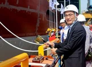 Takaaki Anraku, President, Kokusai Cable Ship Company, cutting the rope to break the milk pot against the vessel’s hull