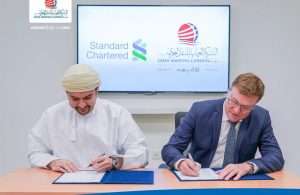Oman Shipping and Standard Chartered executives signing a refinance agreement for five tankers including two VLCCs.