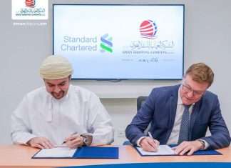 Oman Shipping and Standard Chartered executives signing a refinance agreement for five tankers including two VLCCs.