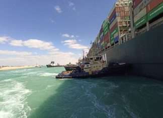 Tugs working to free the stricken container ship in the Suez Canal