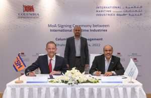 Ahmed Al Saadi, IMI Chairman, watches on as Mark O’Neil, COO of Columbia Shipmanagement and Dr Abdullah Al Ahmari, CEO of IMI sign the MOU