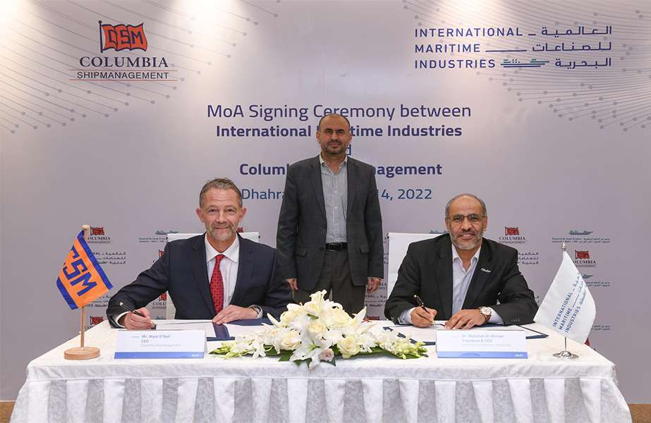 Ahmed Al Saadi, IMI Chairman, watches on as Mark O’Neil, COO of Columbia Shipmanagement and Dr Abdullah Al Ahmari, CEO of IMI sign the MOU